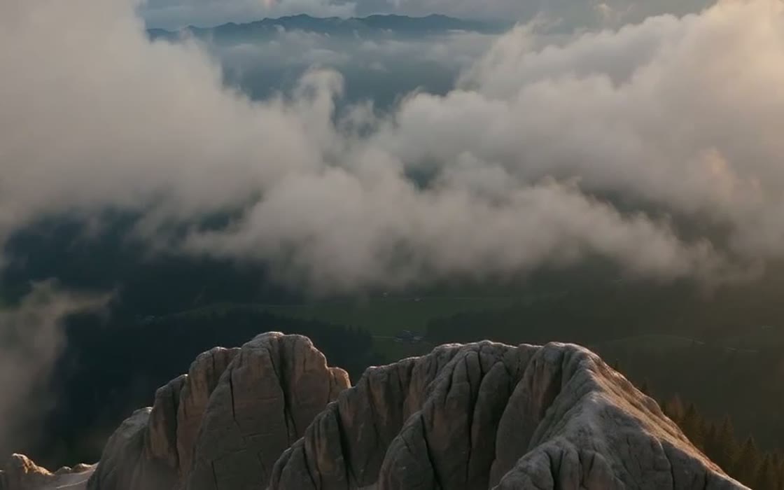 Cresta rocosa sobre un valle cubierto de nubes