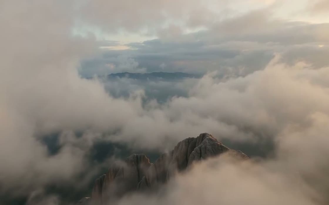 Montañas emergiendo de una capa de nubes